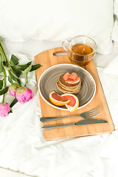 istock Breakfast in bed, Oatmeal pancakes with grapefruit, tea and Peon 532276630