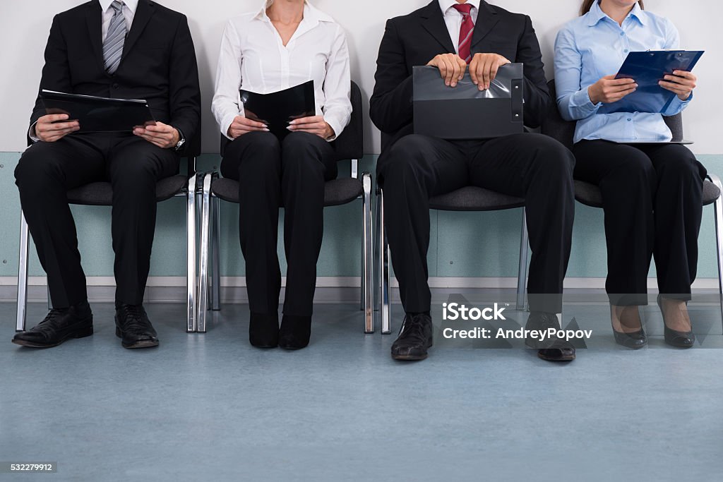 Businesspeople Sitting On Chair Close-up Of Businesspeople With Files Sitting On Chair Unemployment Stock Photo