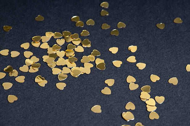istock Many golden heart sparkles on black background 532282909