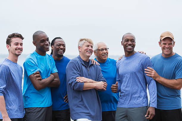 Diverse group of men standing together Multi-ethnic group of men standing together, smiling, supporting one another. Mixed ages ranging from 20s to 70s. only men stock pictures, royalty-free photos & images