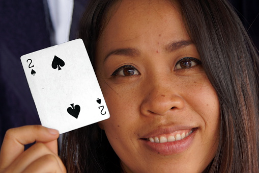 Read em and weep, a concept of a winning poker hand being played. Hand holds winning cards on blue table top with copy space.