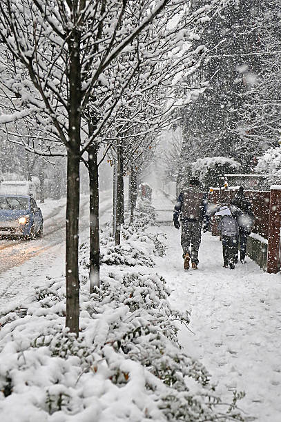 family walks in the city  sidewalk during a copious snowfall