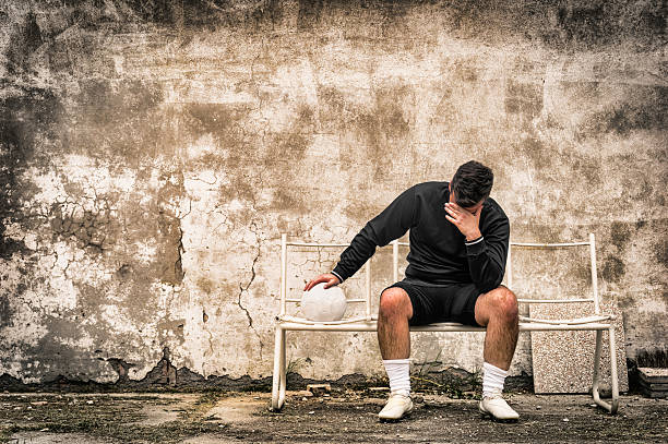 サッカーサッカー選手 desperate 故障の後にスポーツ感 - soccer guilt soccer player sitting ストックフォトと画像