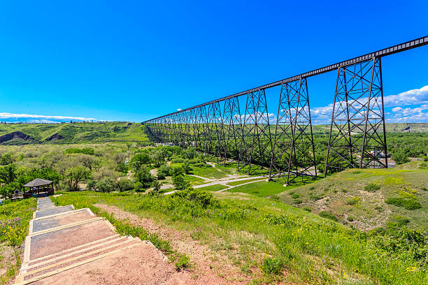 Path by Long and Tall Train Bridge Path by the High Level Bridge in Lethbridge, Alberta, Canada. The bridge is the longest and highest trestle bridge in the world soaring above the Oldman River. lethbridge alberta stock pictures, royalty-free photos & images