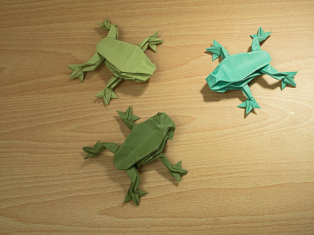 Three Origami Frogs on wood stock photo