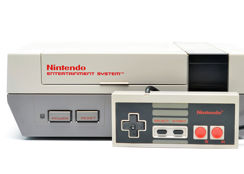 Vancouver, B.C., Canada -- January, 14, 2015:Closeup of an old Nintendo Entertainment System and Controller from the 1980s on a white background.