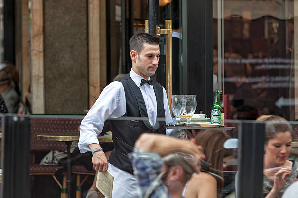 Paris, France - July 15, 2014: Waiter serving drinks in Cafe Les Deux Magots at the corner of Boulevard Saint-Germain and Rue  Bonaparte.