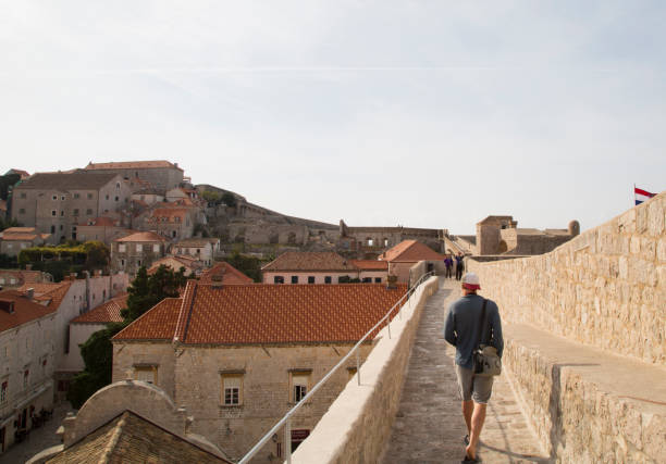 view from stone fortification wall of the old town of Dubrovnik, beautiful background with stone wall, ancient architecture and red roofs