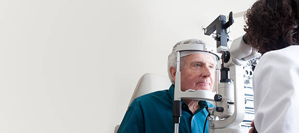 Optometrist with patient Optometrist giving eye exam to senior patient cornea photos stock pictures, royalty-free photos & images