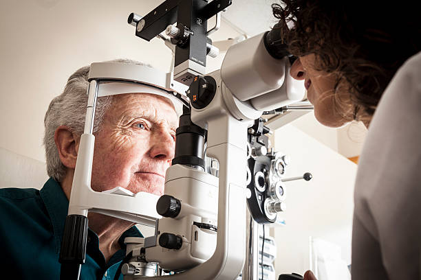 Optometrist with patient Optometrist giving eye exam to senior patient eye checkup stock pictures, royalty-free photos & images