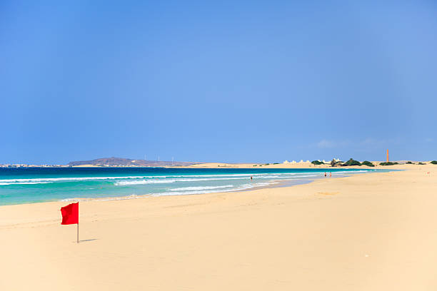 red flag on the beach in Boavista, Cape Verde red flag on the beach in Boavista, Cape Verde - Cabo Verde sand river stock pictures, royalty-free photos & images