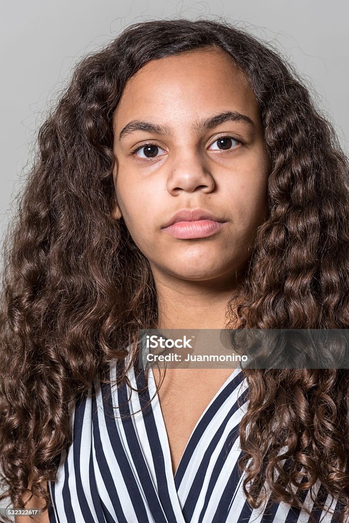 Serious hispanic teenage girl Serious hispanic teenage girl looking at the camera on gray background 14-15 Years Stock Photo
