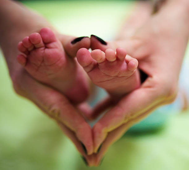 istock Mothers hands and newborn feet 532322649