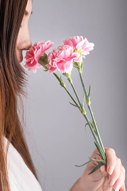 young asian girl holding pink carnation