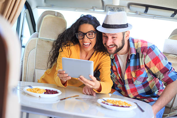 istock Smiling couple using digital tablet inside of a camper van 532329024