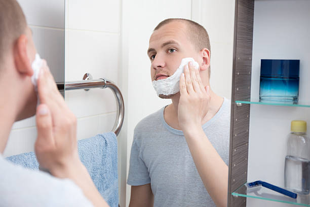 istock handsome young man applying shaving cream to his face 532329054