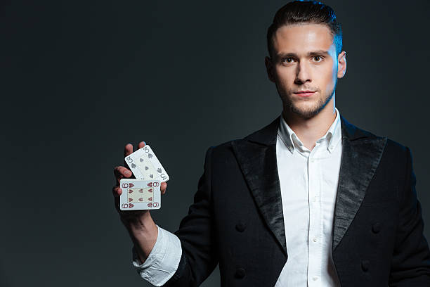istock Serious young man magician standing and holding two playing cards 532333314