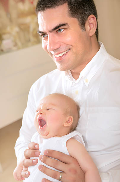istock Happy father with yawning daughter on hands 532334493