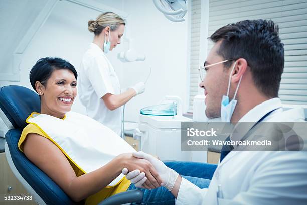 Male Dentist Shaking Hands With Woman Stock Photo - Download Image Now - Dentist, Greeting, Patient