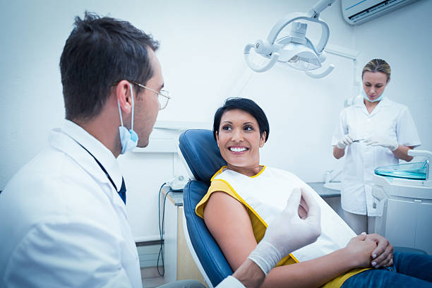 istock Dentist and assistant with smiling female patient 532334847
