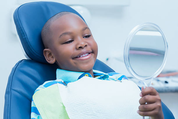 istock Boy looking at mirror in the dentists chair 532335035