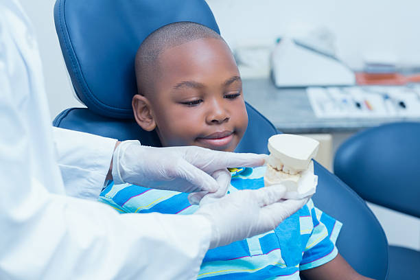 istock Cropped dentist showing boy prosthesis teeth 532335109