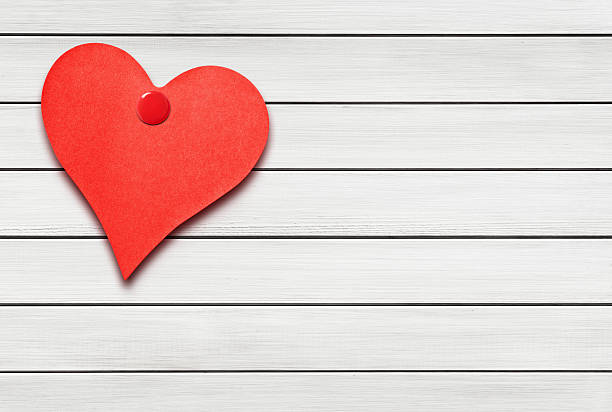 istock Heart shaped note on white wooden wall 532335187
