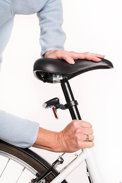 istock Woman sets height of  bicycle saddle before cycling 532336073