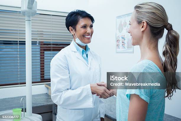 Female Dentist Shaking Hands With Woman Stock Photo - Download Image Now - 2015, 30-39 Years, 35-39 Years