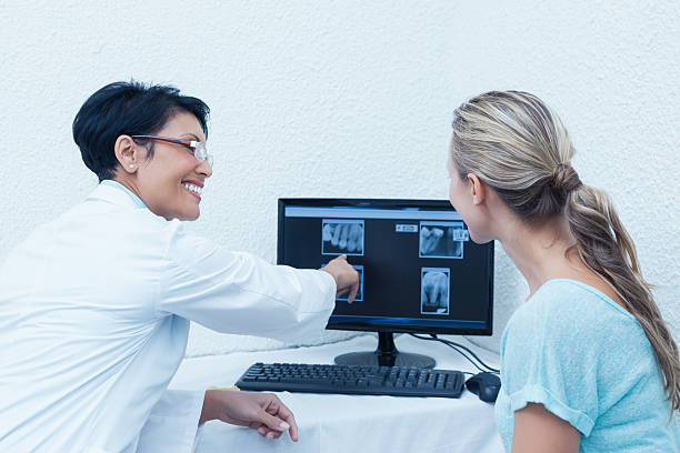 istock Dentist showing woman her mouth x-ray on computer 532336809