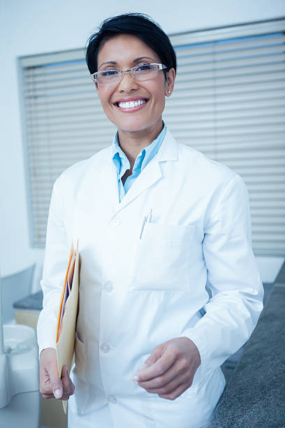 istock Smiling female dentist holding folder 532337015