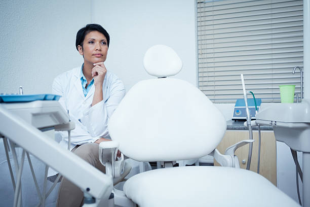 Thoughtful young female dentist stock photo