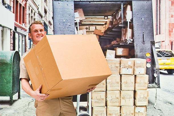 istock Smiling worker holding box outdoors 532338290