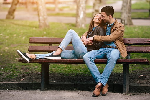 beautiful young couple relaxing on a bench in the park