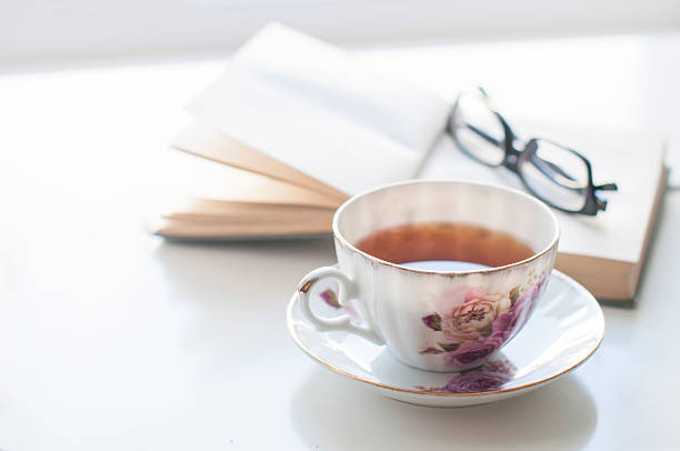 Cup of tea, old book and glasses stock photo