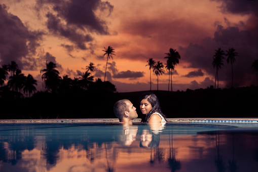 Couple in love reflecting in the pool water