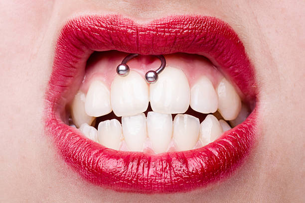 Smiley Piercing Smiley Piercing Detail with Snarling Woman's Mouth Pierced stock pictures, royalty-free photos & images