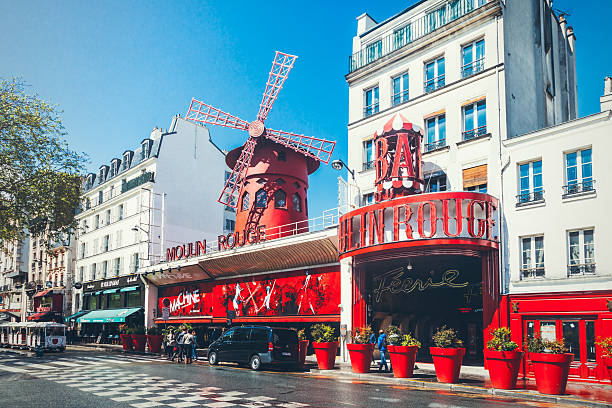 The Moulin Rouge in Paris Paris, France - April 26, 2016: The Moulin Rouge during the sunny day. Moulin Rouge is a famous cabaret built in 1889, locating in the Paris red-light district of Pigalle. place pigalle stock pictures, royalty-free photos & images