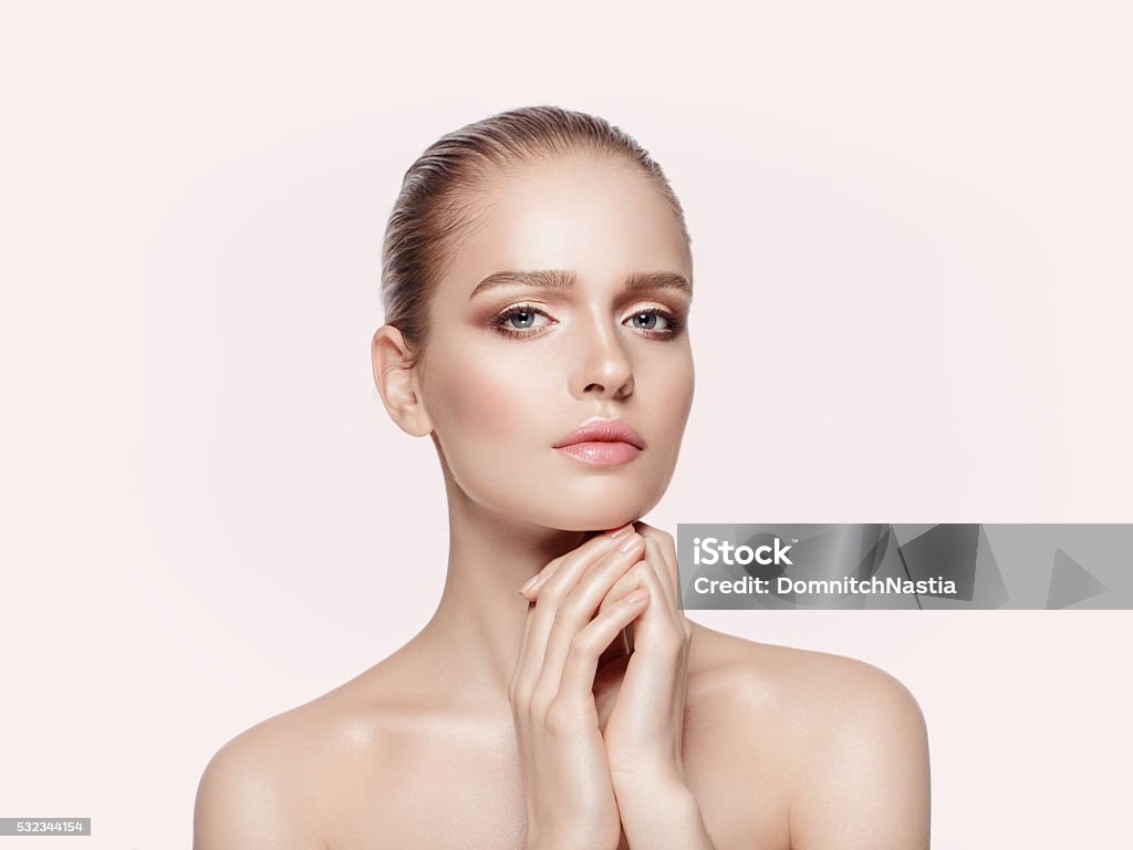 beautiful girl with professional makeup Close up beauty portrait of young model with nude professional makeup. Not isolated, light pink background. Glowing Stock Photo