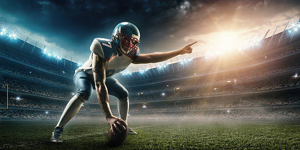 American football player stand A male american football player in playing stand. He wears unbranded professional clothes. Action takes place in a generic outdoor football stadium under a cloudy sky with bright sun.  Touchdown stock pictures, royalty-free photos & images