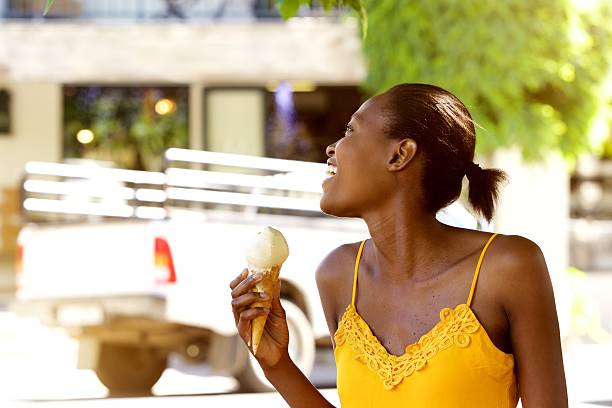 istock Smiling african woman holding ice cream cone outside 532345036