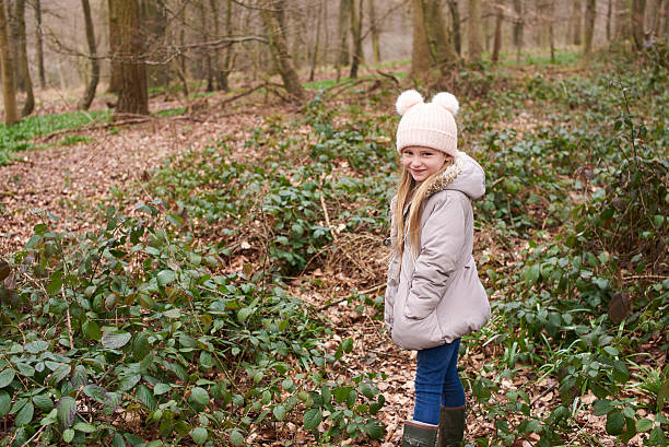 istock Young girl standing alone in forest undergrowth 532345102