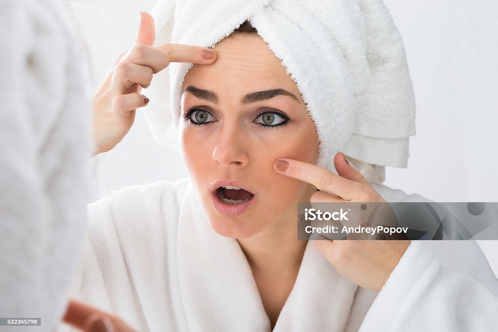 Worried Woman Looking At Pimple On Face Close-up Of Worried Woman Looking At Pimple On Face In Mirror Acne Stock Photo