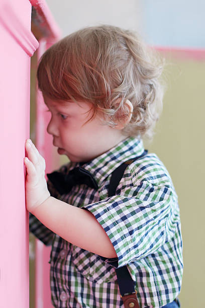 istock Little dreaming boy looks into pink cabinet 532346056