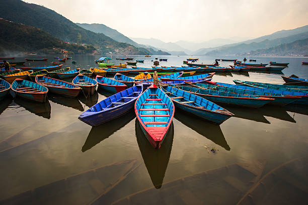 penumbra con barcos en lago phewa, pokhara, nepal - nepal fotografías e imágenes de stock