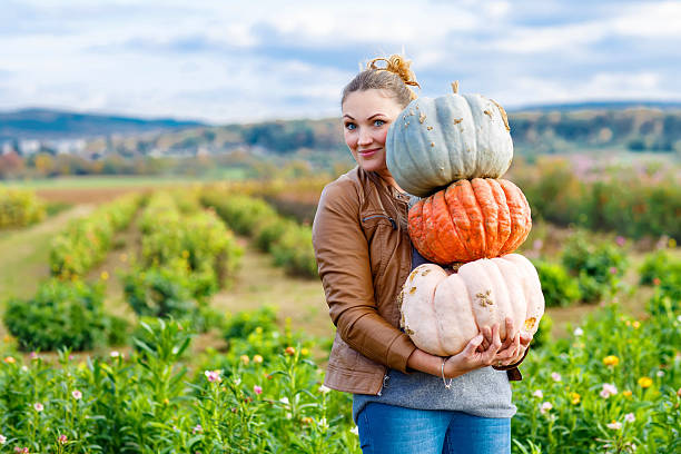 bella donna con tre grandi pumpkins in farm - pumpkin autumn october squash foto e immagini stock