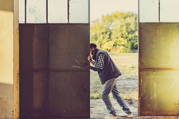 man opening doors of agricultural shed stock photo