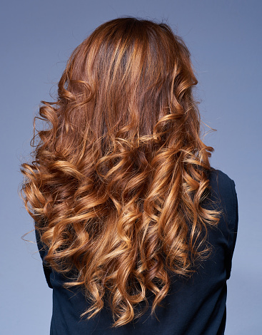 rear view of woman with long hair, curly hairstyle.beauty concept, photo taken inside studio/hair salon.