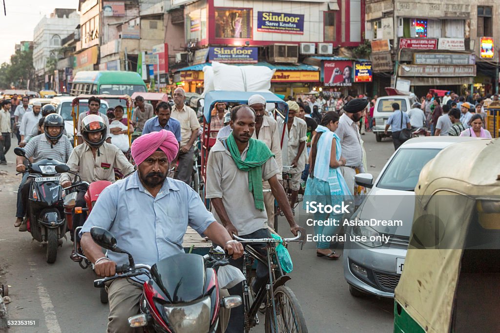 The streets of New Delhi New Delhi, India - September 8 2012: People drive in a busy and chaotic street of New Delhi, the capital city of India. Crowd of People Stock Photo