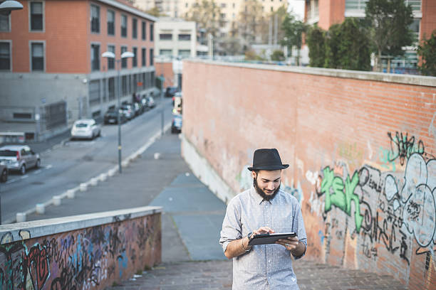 istock young handsome hipster gay modern man using tablet 532353745